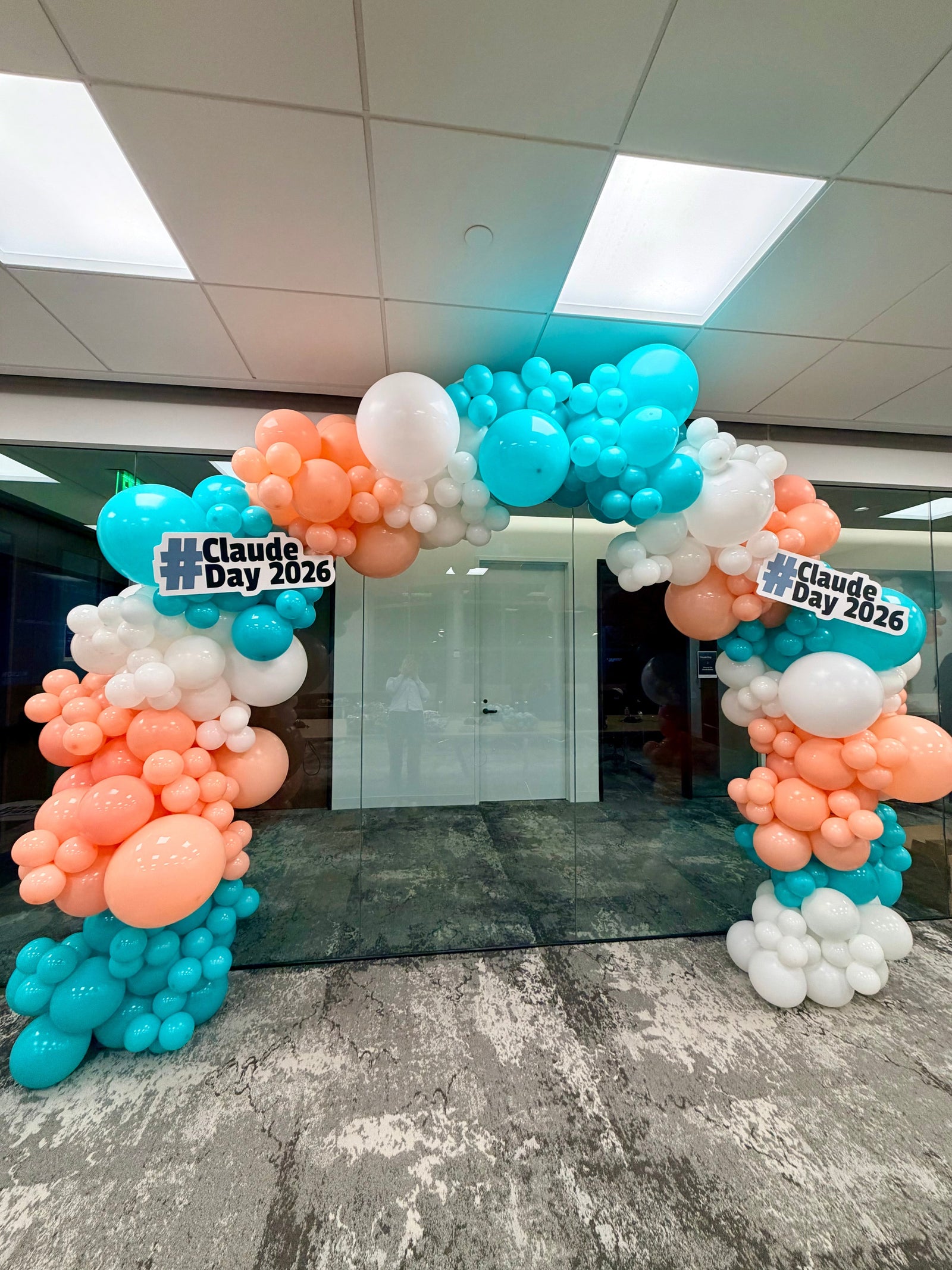 Teal peach and white balloon arch for Claude Day 2026 corporate event in Silicon Valley