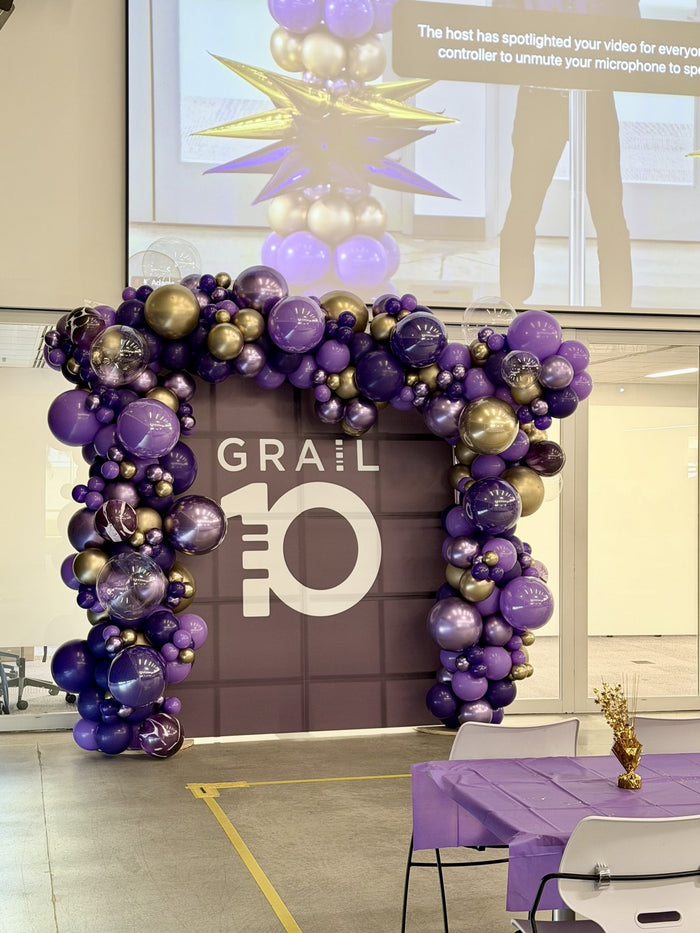 Purple and gold balloon backdrop for GRAIL 10-year anniversary